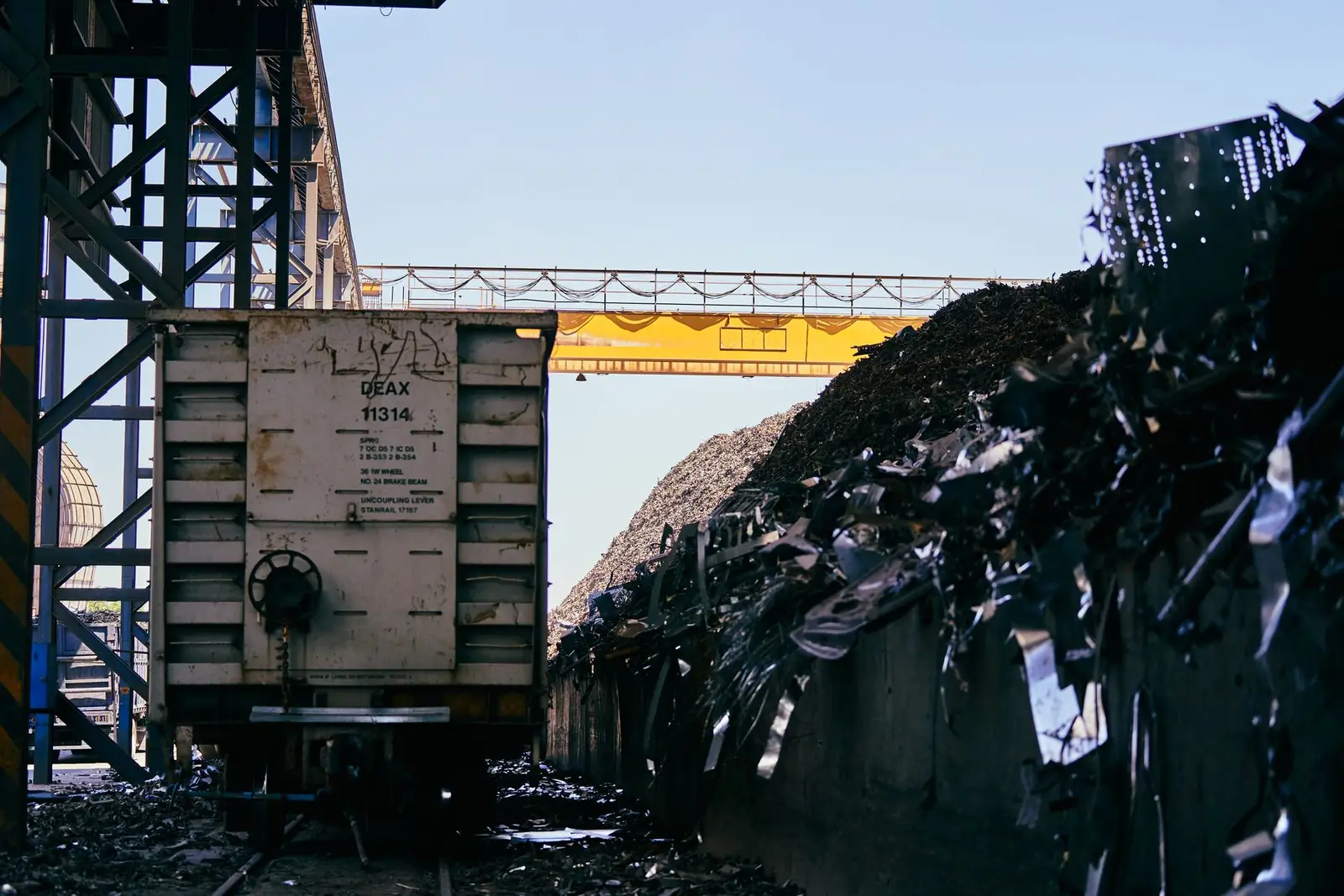 Endüstriyel hurda sahasında metal yığınları ve taşıma vagonu